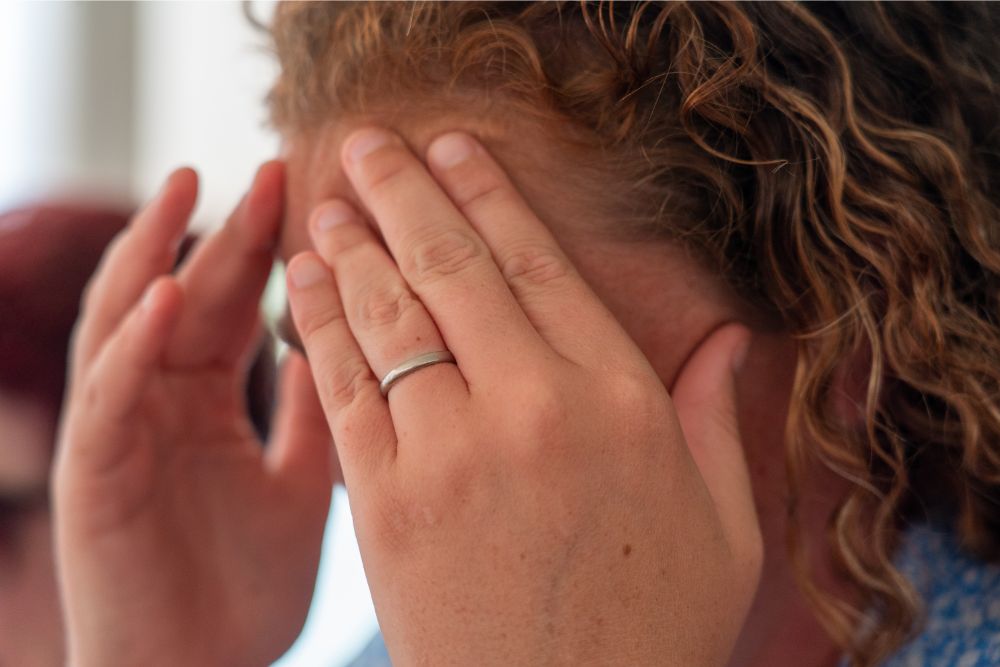 Woman holding her head with both hands